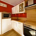 Kitchen with white cabinets, wooden surfaces, and integrated microwave.