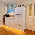 Küche mit Kühlschrank, Arbeitsfläche und Fenster