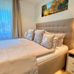 Schlafzimmer mit Bett, Nachttisch und Wandbild.