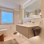 Moderne Badewanne mit Spiegel, Toilette und Fenster mit Blick.