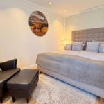 Schlafzimmer mit Bett, Sessel und Wandbild eines Hirsches.