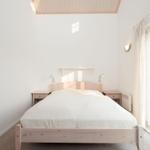 Bedroom with wooden bed, nightstands, and window to terrace.