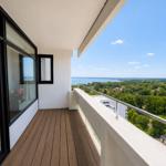 Balcony with wooden floor and view of water and green areas