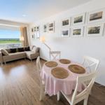 Living and dining area with table, chairs, and view of the landscape.