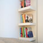 Wandregal mit drei Ebenen und Büchern im Schlafzimmer
