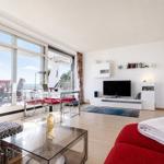 Living room with glass patio, red sofa, and TV wall. Terrace with sea view.