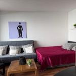 Zimmer mit Sofa, Bett und Wandbild von Charlie Chaplin.