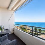 Balcony with table, chairs, and view of the sea.