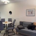 Living and dining area with sofa, table, and kitchenette.