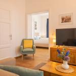 Wohnzimmer mit Fernseher, Sessel und Blick in Schlafzimmer