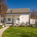 Wohnhaus mit Terrasse, Liegen und Whirlpool im Garten.