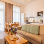 Wohn- und Essbereich mit Sofa, Tisch, Küchenzeile und Fenster