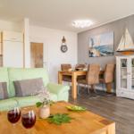 Wohn- und Essbereich mit Sofa, Esstisch und Küchenzeile.