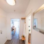 Flur mit Spiegel, Garderobe und Blick in Esszimmer und Bad