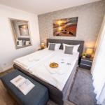 Schlafzimmer mit Bett, Wandbild und Nachttischen
