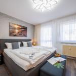 Schlafzimmer mit Doppelbett, Fenster, Nachttisch und Wandbild.