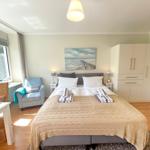 Schlafzimmer mit Doppelbett, Kleiderschrank und Fensterblick.
