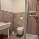 Badezimmer mit Dusche, Toilette und Waschbecken.