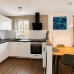 Küche mit Essbereich, Holzboden und Fenster zum Garten
