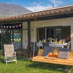 große Terrasse mit gepflegtem Garten und Hollywoodschaukel