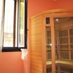 Sauna with wooden cladding and window with curtains on orange wall.