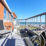 Balcony with chair and table overlooking the sea.