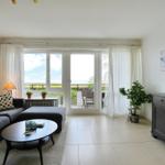 Wohnzimmer mit Sofa, Couchtisch und TV. Balkon mit Meerblick.