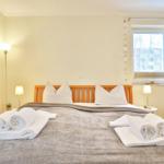 Bedroom with bed, nightstands, and window. Towels are neatly placed on the bed.