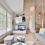 Living room with sofa, TV, and spiral staircase