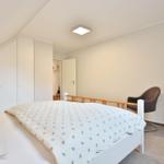 Bedroom with bed, wardrobe, and armchair.