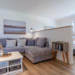 Wohnbereich mit Sofa, Couchtisch und Blick auf Schlafzimmer.