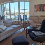 Living room with sofa, armchair, and view of the lake