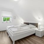 Bedroom with double bed, window, and nightstand