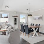 Living and dining area with sofa, dining table, and windows.