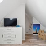 Bedroom with TV, cabinet, and light image on the wall.
