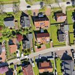 Aerial view of houses with gardens and streets in a quiet neighborhood.