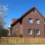 Red brick house with wooden fence and blue sky