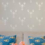 Wand mit Hummer-Motiv, grauer Sofa mit blauen Kissen und Tulpen im Vordergrund.