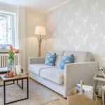 Wohnzimmer mit Sofa, Wand mit Hummermotiv, Tisch und Fenster