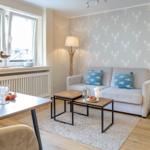 Wohnzimmer mit Sofa, Tisch und Fenster. Wandtapete mit Krebselementen.
