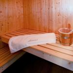 Sauna mit Holzbank, Handtuch und Eimer