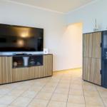 Wohnzimmer mit TV, Sideboard und Glasvitrine. Holz- und Glasfronten.
