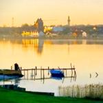 Hafen mit Boot und Blick auf Stadt bei Sonnenuntergang