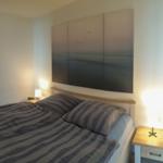 Bedroom with bed, nightstands, and wall art