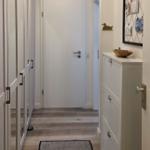 Hallway with wardrobe, drawer, and rug