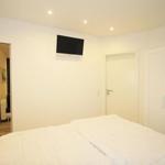Bedroom with bed, wardrobe, and wall-mounted TV