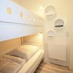 Room with bunk bed and round wall holders.