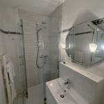 Bathroom with shower, sink, and mirror.