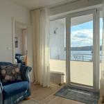 Living room with view of the lake through glass door and balcony