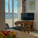 Dining room with water view, TV, and fruit bowl on table